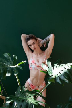 Stüdyoda mayo giymiş genç ve güzel bir kadın.