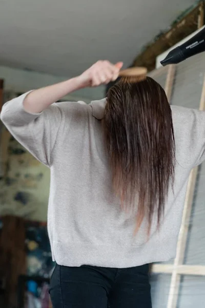 Молодая Красивая Женщина Расчесывает Волосы Феном — стоковое фото