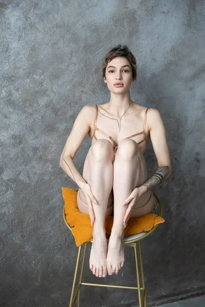 Junge Schöne Frau Sitzt Auf Einem Stuhl Mit Ihren Beinen — Stockfoto