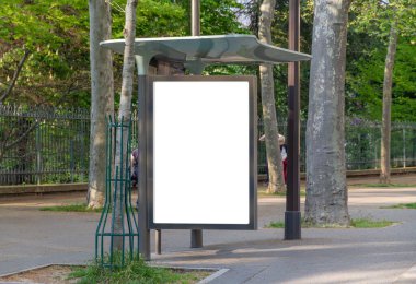 Paris 'te boş bir sokakta otobüs durağı reklam panosu modeli. Paris tarzı reklamlar güzel bir şehrin parkına yakın bir yerde.