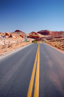 verlaten weg die zich uitstrekt naar de horizon in de vallei van brand staatspark, nevada