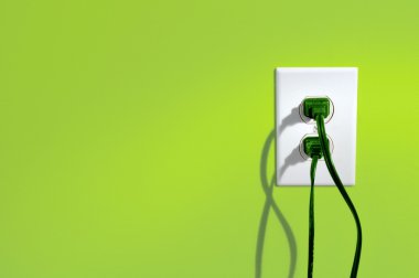 yeşil enerji elektrik prizine yeşil renkli duvar - yeşil enerji kavramı içinde kordonlar