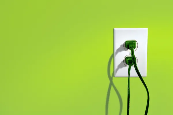 yeşil enerji elektrik prizine yeşil renkli duvar - yeşil enerji kavramı içinde kordonlar