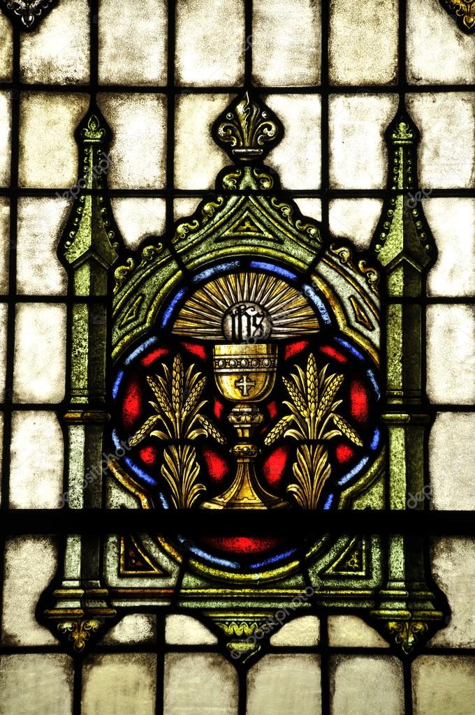 Vidriera con un cáliz y sol inscritos IHS (Iesus Hominum Salvator, A Su