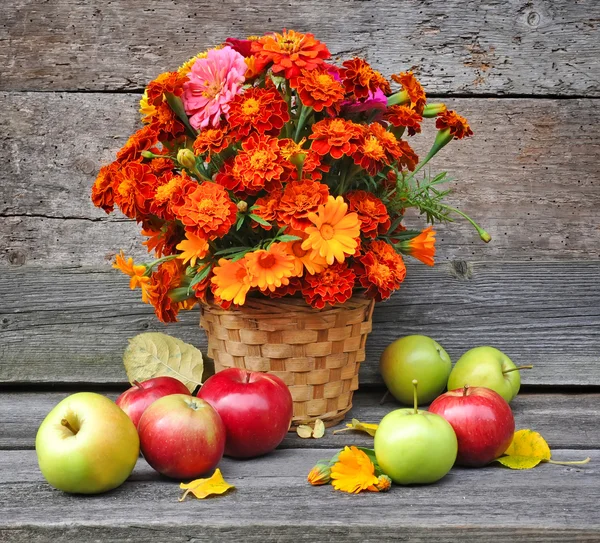 Bouquet of autumn flowers is with apples on an old wooden background — Stock Photo, Image