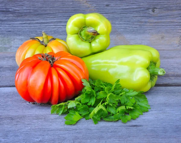 Fresh tomatoes (sort Beauty Lottringa), sweet green peppers and parsley on an old wooden table — Stock Photo, Image