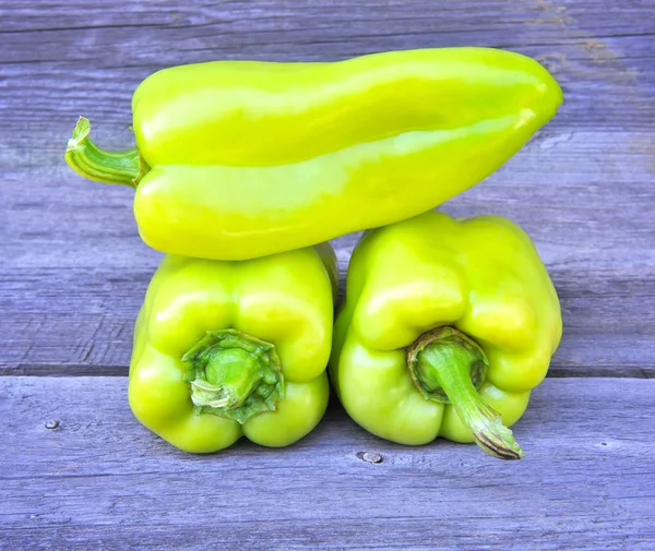 Verse zoete groene paprika's op een oude houten tafel — Stockfoto