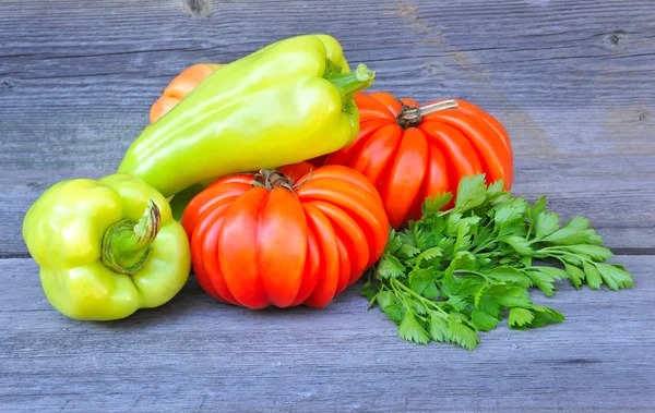 Fresh tomatoes (sort Beauty Lottringa), sweet green peppers and parsley on an old wooden table — Stock Photo, Image