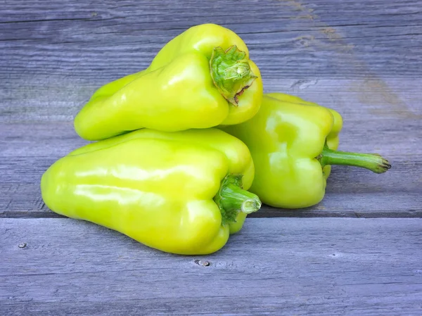 Verse zoete groene paprika's op een oude houten tafel — Stockfoto