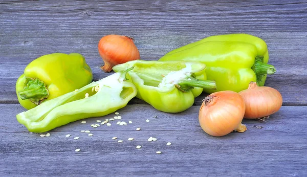 Čerstvé sladké zelené papriky a cibule na starý dřevěný stůl — Stock fotografie