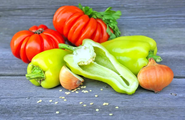 Verse zoete groene paprika's met ui en tomaten (soort schoonheid Lottringa) op een oude houten tafel — Stockfoto