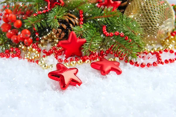 Decorazioni natalizie di gingillo sono con i rami di abete sulla neve — Foto Stock