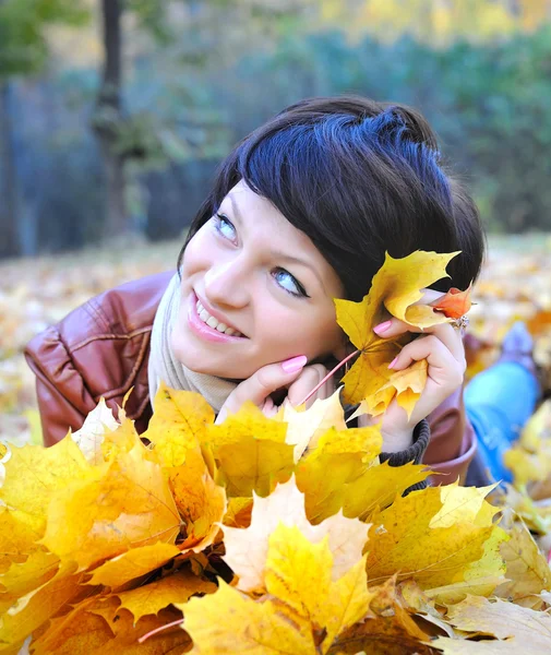 Girl in autumn with maple leaves — Stock Photo, Image