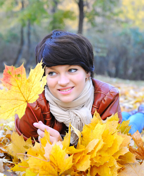 Girl in autumn with maple leaves