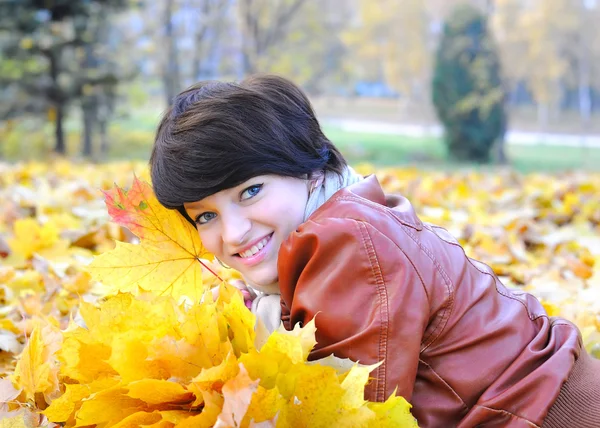 Girl in autumn with maple leaves — Stock Photo, Image