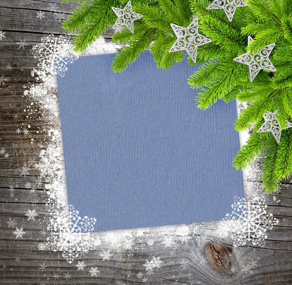 Foglio di carta natalizia con i rami di abete rosso su sfondo di legno con fiocchi di neve — Foto Stock