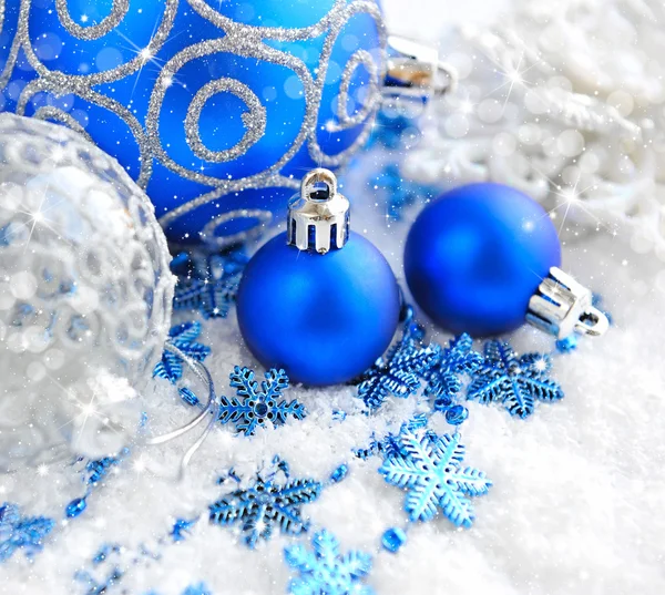 Рождественские синие и серебряные украшения на снегу — стоковое фото