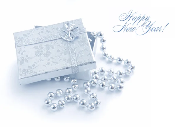 Un petit cadeau est avec des perles de Noël sur un fond blanc — Photo