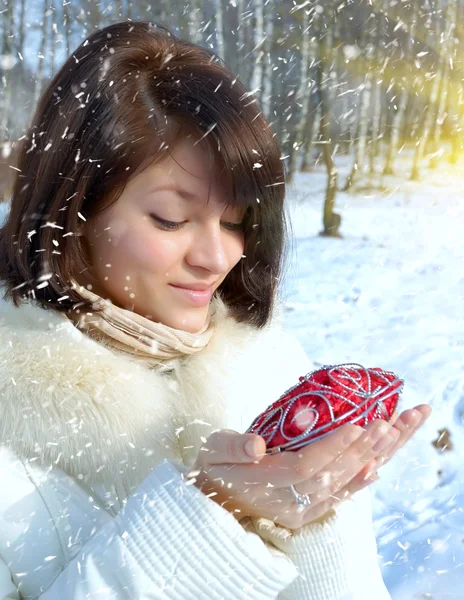 Winter girl with a decorative heart — Stock Photo, Image