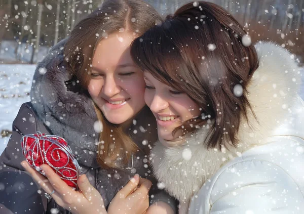 Two girls with a decorative heart in winter — Stock Photo, Image