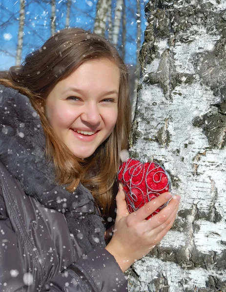 Winter girl with a decorative heart — Stock Photo, Image