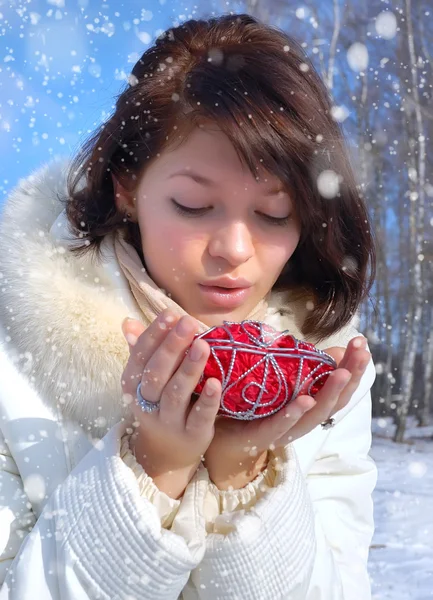 Winter girl with a decorative heart — Stock Photo, Image