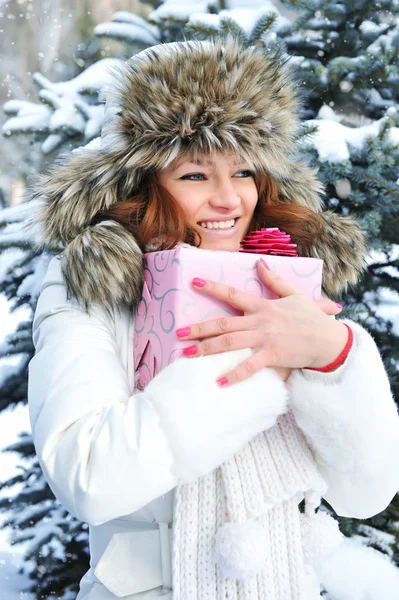 Ein junges Mädchen ist mit einem Geschenk im Winterpark — Stockfoto