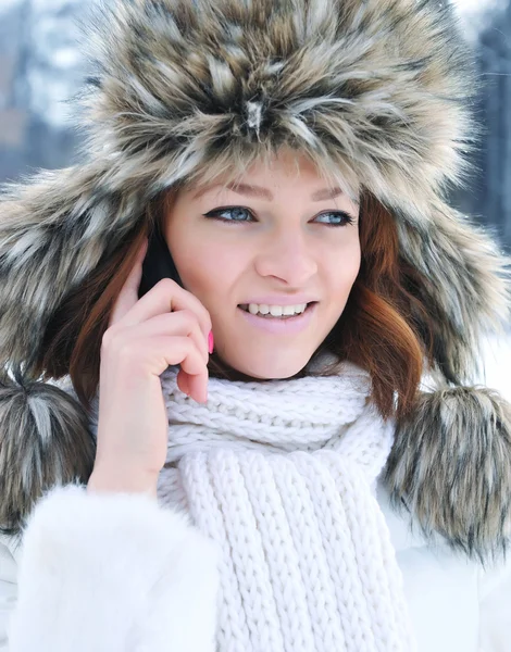 Beautiful young woman with mobile phone in winter — Stock Photo, Image