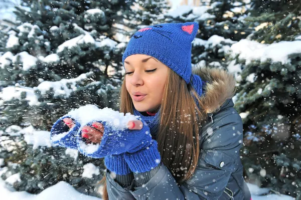 Inverno giovane ragazza soffiando neve — Foto Stock