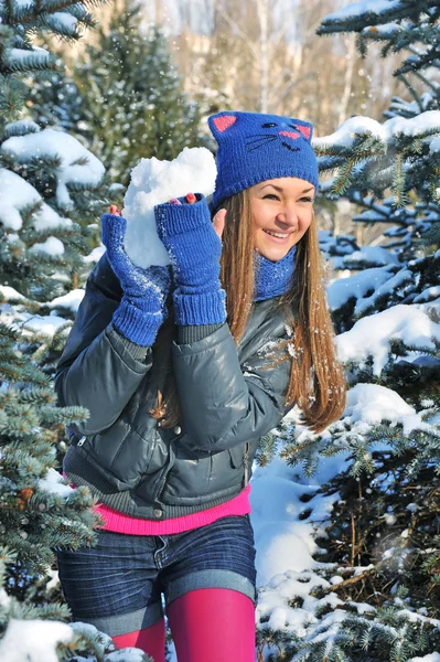 Winter vrouw spelen sneeuwballen op sneeuw achtergrond — Stockfoto