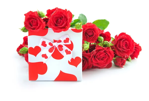 Malý dárek s červenými růžemi na bílém pozadí — Stock fotografie