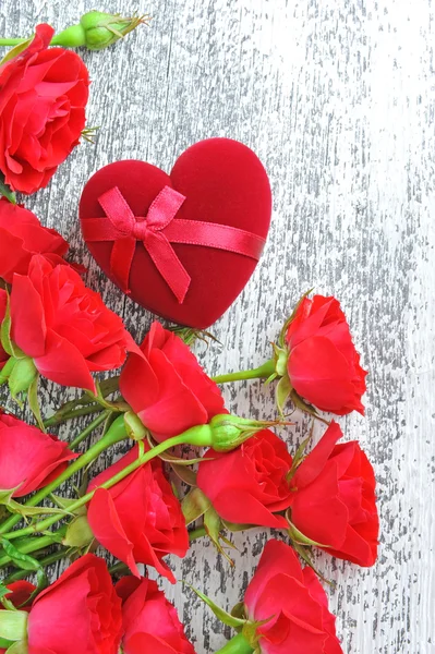 Rosas vermelhas com caixa de presente em forma de coração em fundo de madeira — Fotografia de Stock