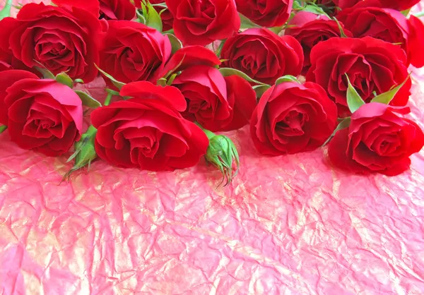 Rosas vermelhas em um contexto um papel de empacotamento — Fotografia de Stock