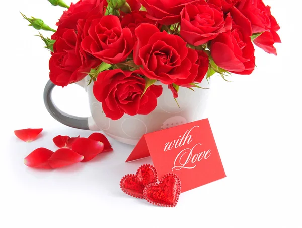 Red roses are with the card of greeting on a white background — Stock Photo, Image