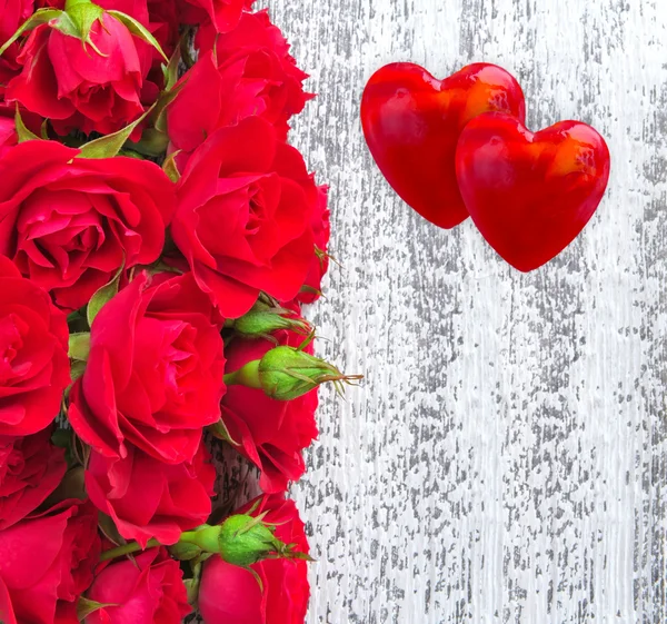 Two hearts with red roses on a wooden background — Stock Photo, Image