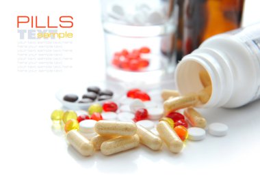 Capsules that pour out from a bottle on a white background clipart