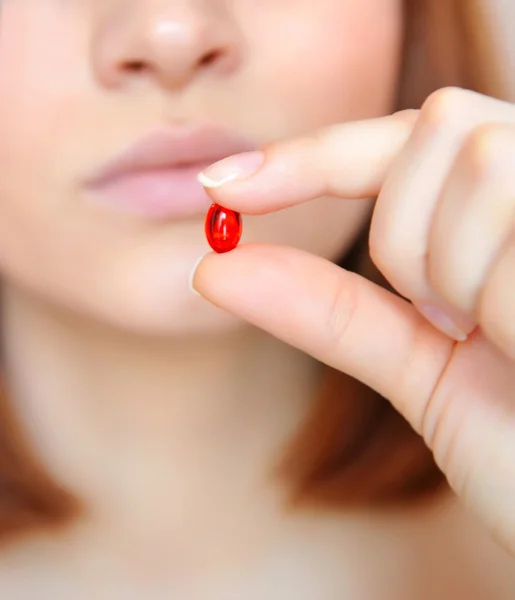 Ung kvinna med p-piller. fokus ligger på ett piller — Stockfoto