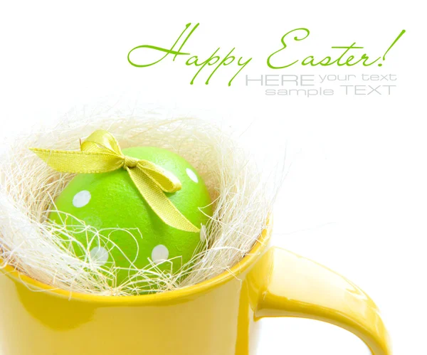 Easter egg in yellow cup on a white background — Stock Photo, Image