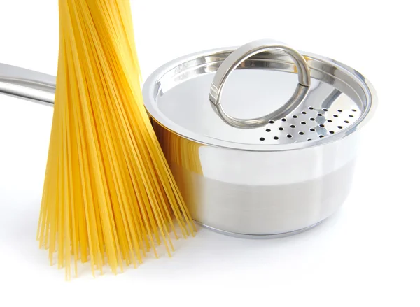 Куча спагетти и сковородки на белом фоне — стоковое фото