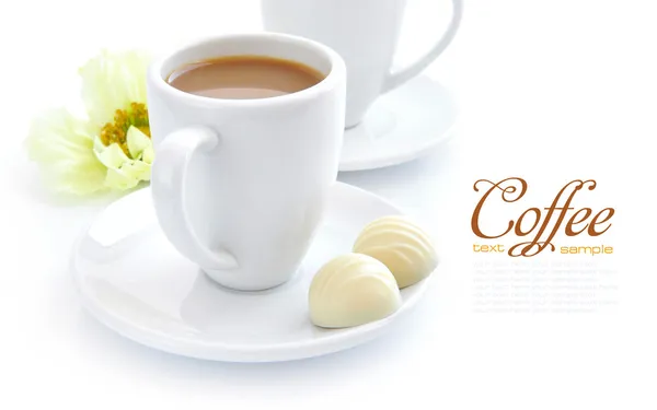 Cup of coffee with candies on white background — Stock Photo, Image