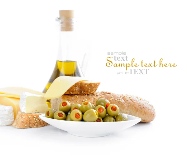 Green olives, oil, slices of bread and cheese are on a white background — Stock Photo, Image