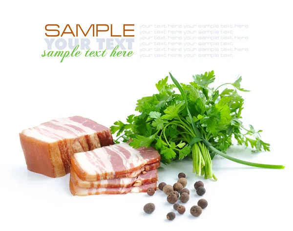 Pedaços de bacon são com o bando de salsa verde e por grãos de pimenta em um fundo branco — Fotografia de Stock