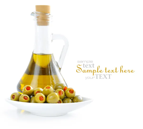 Olive verdi farcite con pimento con bottiglia di olio su fondo bianco — Foto Stock