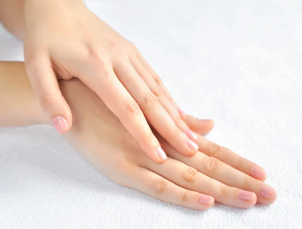 Beautiful woman hands are on a white towel — Stock Photo, Image