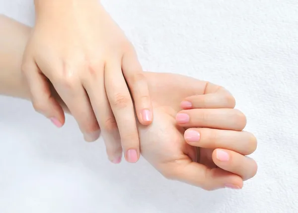 Beautiful woman hands are on a white towel — Stock Photo, Image