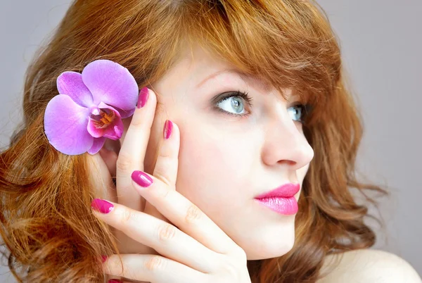 Hermosa chica sosteniendo flor de orquídea en sus manos —  Fotos de Stock