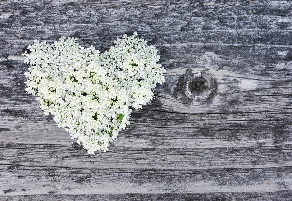 Herz aus Blumen auf altem Holzgrund — Stockfoto