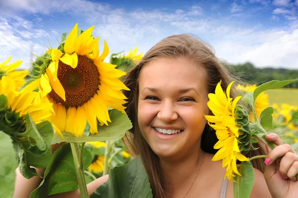 Jonge mooie vrouw op een zonnebloem gebied. zomerpicknick — Stockfoto
