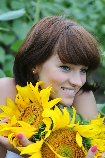 Joven hermosa mujer en un campo de girasol — Foto de Stock