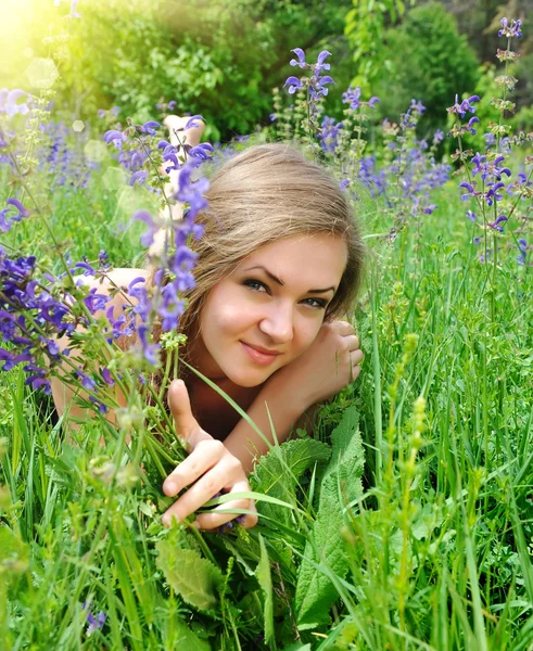 Красивая молодая женщина в фиолетовых цветах на открытом воздухе — стоковое фото